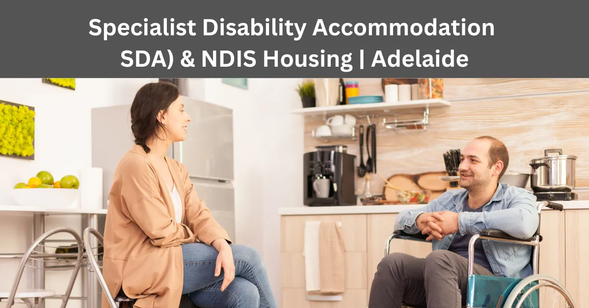 Two adults in wheelchairs talking comfortably in a well-designed, accessible kitchen under an SDA and NDIS housing banner.